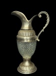 METAL PRATEADO e VIDRO, uma (1) jarra confeccionada em vidro translucido com moldagem bico de jaca, gargalo e base confeccionado em metal espessurado a prata com cinzelado de caneluras, medindo 23cm de altura.