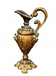 DIVERSOS, uma (1) ânfora decorativa confeccionada em resina com patina em ouro velho, ricamente decorada por gomos torcidos, elementos florais e vegetalistas e rosto de Puttinos em relevo, não possui furo, é peça decorativa, medindo 33cm de altura.