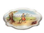 Jean Pouyat (J. Pouyat), Limoges, France, uma (1) travessa oval decorativa confeccionada em porcelana francesa na tonalidade branca, decorada por cena campestre com figura feminina em policromia e borda filetada na cor marrom, medindo 41x23cm.
