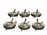 METAL PRATEADO, seis (6) taças para sobremesa com suas respectivas colheres confeccionadas em metal espessurado a prata com alça cinzelada em folhagens, apoiada sobre 3 pés curvos, acondicionada em estojo original com leves marcas do tempo, medindo 4x11x8,5cm.