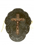 ARTE SACRA, um (1) crucifixo de parede confeccionado em resina com patina bronze, apoiada sobre placa em madeira com recortes na borda, entalhes de repuxados e elementos florais com patina escura, medindo 38,5x28cm.