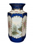 PORCELANA SÃO CAETANO, um (1) vaso sextavado confeccionado em porcelana nacional na tonalidade branca, espessas faixas na tonalidade azul escuro, pintura de paisagens, guirlandas e elementos florais em policromia com guirlanda vegetalistas em vasta douração, medindo 35x14,5cm.