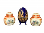 PORCELANAS, lote com três (3) peças, sendo: A) 2 potiches confeccionados em porcelana na tonalidade branca, decorado por faixas na tonalidade vermelha, elementos florais, vegetalistas e faisões em policromia, medindo 7cm de altura e B) 1 caixa porta joias no feitio de ovo em porcelana na tonalidade azul cobalto, ricamente decorada por elementos florais e vegetalistas em douração com borda em metal dourado, medindo 10x6cm.