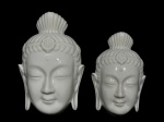 PORCELANAS, duas (2) esculturas decorativas de parede em porcelana branca, representando faces de divindade oriental (Buda), com expressão serena, olhos semicerrados, orelhas alongadas e adorno floral frontal, acabamento esmaltado brilhante, maior medindo 16x9cm e menor 13x8cm.