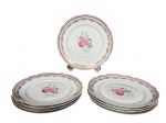 PORCELANA REAL, nove (9) pratos para sobremesa confeccionadas em porcelana nacional na tonalidade branca, decorada por faixa na tonalidade vinho, pintura de flores e folhagens em policromia e guirlanda floral em vasta douração, borda filetada com falhas na douração, medindo 18,5cm.