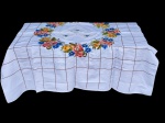 CAMA, MESA & BANHO, conjunto composto por uma (1) toalha de mesa em tecido branco e três (3) guardanapos, apresentando bordados florais policromados dispostos em guirlanda central, além de padronagem quadriculada bordada ao longo do campo da peça, toalha medindo 150x150cm e guardanapos 25,5x25,5cm.
