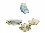 PORCELANAS, lote com quatro (4) peças em miniatura confeccionadas em porcelana de modelos, tamanhos e decorações distintas, sendo: A) 1 cinzeiro no feitio de sapato, medindo 6x9cm, B) 1 pequena travessa decorativa, medindo 10x7cm, C) 1 pequena cesta, medindo 4x7x4,5cm (bicado na borda) e D) 1 xícara com seu respectivo pires, marcado L, possivelmente Limoges, medindo 3x5x3cm.