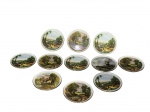 PORCELANAS, onze (11) porta copos confeccionados em porcelana na tonalidade branca com pintura de paisagens distintas em policromia e borda filetada em ouro, medindo 8,5cm.