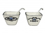 FAIANÇA OXFORD, par (2) de cremeiras confeccionadas em faiança na tonalidade branca, decoradas por elementos florais em monocromia nas tonalidades azul e preta, ambas acompanham colheres e pintura descascando, medindo 6x7,5x7,5cm.