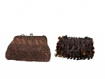 <B>ACESSÓRIOS FEMININOS</b>, duas (2) bolsas clutch confeccionadas em tecido acetinado na tonalidade marrom, sendo: A) 1 decorada por rendas e pingentes em missangas e plásticos dourados, medindo 10x18cm e B) 1 decorada por faixas retorcidas, fecho em metal escuro, apresentando desgastes na borda, medindo 18x21,5cm.