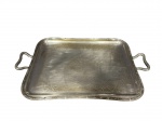 METAL PRATEADO, uma (1) bandeja retangular confeccionada em metal espessurado a prata com borda cinzeladas em caneluras, fitas e rosas, modelo dito ROSINHA, fundo em elementos vegetalistas com alças em ondulações, apresenta falhas na prateação, medindo 51x32cm.