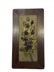 QUADRO, um (1) painel emoldurado representando flores e folhagens em pedras brasileiras apoiada sobre placa retangular em madeira escura, medindo 47,5x25cm. Assinado no verso.