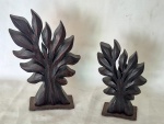 Duas esculturas em madeira e base em ferro representando arvore medindo a maior 24 cm de altura por 18 cm por 4 cm.