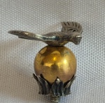 Escultura em prata representando a Pomba do Espirito Santo sobre esfera em prata vermeil pequeno formato medindo 2 cm de altura por 2,5 cm por 2,2 cm.
