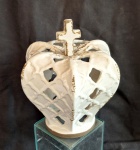 Coroa de Nossa Senhora em porcelana vitrificada encimada por cruz medindo 21 cm de altura por 19 cm de diâmetro.