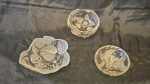 Três petisqueiras em vidro decorado com flores e folhagens medindo 6 cm por 18 cm por 16 cm,  7 cm por 14 cm de diâmetro e 3 cm por 13 cm de diâmetro.