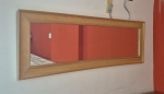 Espelho emoldurado em madeira medindo 45 cm por 142 cm.