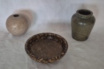 Três peças em pedra sabão sendo vaso medindo 15 cm por 12 cm de diâmetro, vaso redondo medindo 12 cm de diâmetro e prato medindo 6 cm por 19 cm de diâmetro.