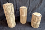 Três velas decorativas feitas apartir de tocos de bambu natural medindo o maior 25 cm de altura por  cm de diâmetro e o menor 15 cm de altura.