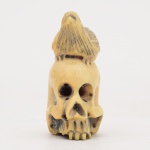 Netsuke, botão para kimono, em marfim oriental represntando caveira com pássaro. Peça assinada. Medida: cm