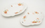Par de travessas em porcelana portuguesa Vista Alegre. Decoração de flores em porcelana branca. Apresentam monograma "JTC". Travessa menor com "ostra" na borda. Medidas: 45 x 31 cm e 38 x 27 cm.