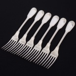 Christofle, Paris - França(Fundada em 1830 por Charles Christofle). Luxuoso conjunto de garfos grandes confeccionadas em metal espessurado à prata, fabricação francesa do início do século XX, executado ao estilo do período Louis Philippe. Padrão "Chinon", usado a partir de 1862, conhecido anteriormente como "filet" ou "vieux Paris". Cabo apresenta "ombros" e margem contornada por frisos de terminação cordiforme sobre extremo arredondado. Composto de seis(06) unidades. Marca da manufatura puncionada no verso do cabo. Med.: Comp. 20 cm.