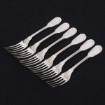 Christofle, Paris - França(Fundada em 1830 por Charles Christofle). Luxuoso conjunto de garfos para sobremesa confeccionadas em metal espessurado à prata, fabricação francesa do início do século XX, executado ao estilo do período Louis Philippe. Padrão "Chinon", usado a partir de 1862, conhecido anteriormente como "filet" ou "vieux Paris". Cabo apresenta "ombros" e margem contornada por frisos de terminação cordiforme sobre extremo arredondado. Composto de seis(06) unidades. Marca da manufatura puncionada no verso do cabo. Med.: Comp. 16,5 cm.