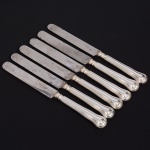 Christofle, Paris - França(Fundada em 1830 por Charles Christofle). Luxuoso conjunto de facas médias confeccionadas em metal espessurado à prata, fabricação francesa do início do século XX, executado ao estilo do período Louis Philippe. Padrão "Chinon", usado a partir de 1862, conhecido anteriormente como "filet" ou "vieux Paris". Cabo apresenta "ombros" e margem contornada por frisos de terminação cordiforme sobre extremo arredondado. Lâminas em aço marcada CHRISTOFLE A PARIS(apresentam sinais de oxidação). Composto de seis(06) unidades. Marca da manufatura puncionada no verso do cabo. Med.: Comp. 21 cm.