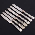 Christofle, Paris - França(Fundada em 1830 por Charles Christofle). Luxuoso conjunto de facas médias confeccionadas em metal espessurado à prata, fabricação francesa do início do século XX, executado ao estilo do período Louis Philippe. Padrão "Chinon", usado a partir de 1862, conhecido anteriormente como "filet" ou "vieux Paris". Cabo apresenta "ombros" e margem contornada por frisos de terminação cordiforme sobre extremo arredondado. Lâminas em aço marcada CHRISTOFLE A PARIS(apresentam sinais de oxidação). Composto de seis(06) unidades. Marca da manufatura puncionada no verso do cabo. Med.: Comp. 21 cm.