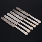 Christofle, Paris - França(Fundada em 1830 por Charles Christofle). Luxuoso conjunto de facas grandes confeccionadas em metal espessurado à prata, fabricação francesa do início do século XX, executado ao estilo do período Louis Philippe. Padrão "Chinon", usado a partir de 1862, conhecido anteriormente como "filet" ou "vieux Paris". Cabo apresenta "ombros" e margem contornada por frisos de terminação cordiforme sobre extremo arredondado. Lâminas em aço marcada CHRISTOFLE A PARIS(apresentam sinais de oxidação). Composto de seis(06) unidades. Marca da manufatura puncionada no verso do cabo. Med.: Comp. 26 cm.