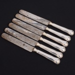 Christofle, Paris - França(Fundada em 1830 por Charles Christofle). Luxuoso conjunto de facas grandes confeccionadas em metal espessurado à prata, fabricação francesa do início do século XX, executado ao estilo do período Louis Philippe. Padrão "Chinon", usado a partir de 1862, conhecido anteriormente como "filet" ou "vieux Paris". Cabo apresenta "ombros" e margem contornada por frisos de terminação cordiforme sobre extremo arredondado. Lâminas em aço marcada CHRISTOFLE A PARIS(apresentam sinais de oxidação). Composto de seis(06) unidades. Marca da manufatura puncionada no verso do cabo. Med.: Comp. 26 cm.
