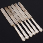 Christofle, Paris - França(Fundada em 1830 por Charles Christofle). Luxuoso conjunto de facas grandes confeccionadas em metal espessurado à prata, fabricação francesa do início do século XX, executado ao estilo do período Louis Philippe. Padrão "Chinon", usado a partir de 1862, conhecido anteriormente como "filet" ou "vieux Paris". Cabo apresenta "ombros" e margem contornada por frisos de terminação cordiforme sobre extremo arredondado. Lâminas em aço marcada CHRISTOFLE A PARIS(apresentam sinais de oxidação). Composto de seis(06) unidades. Marca da manufatura puncionada no verso do cabo. Med.: Comp. 26 cm.