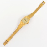 Relógio de pulso feminino da marca Citizen, movimento a quartzo. Caixa de formato retangular com cantos arredondados, executada em liga metálica com acabamento dourado e decoração geométrica gravada na superfície frontal, mostrador em acrílico, dial de tonalidade clara com índices aplicados em formato bastão, marcação perimetral de minutos, inscrição Citizen Quartz na metade superior e iniciais CQ na metade inferior. Ponteiros centrais para horas, minutos e segundos. Coroa lateral canelada para ajuste. Fundo confeccionado em aço, contendo inscrições do fabricante, indicação de material, numeração de referência e país de fabricação. Bracelete integrado decorado com padrão geométrico contínuo, articulado, dotado de fecho dobrável com trava. Não está funcionando. Apresenta pequenos desgastes e marcas de uso, visíveis nas fotografias. Medida: Comp.: 17 cm. Caixa: 3 x 2 cm.