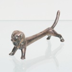 Antigo decanso de talher confeccionado em metal espessurado à prata, execução represnetando cão da raça dachshund. Medidas: Alt.: 3,5 x Comp.: 10 x Larg.: 2 cm.