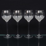 Belíssimo conjunto de taças de pé alto, para vinho do Porto, executado em fino cristal europeu, diáfano e incolor; bojo globular, fundo preenchido e talhado com flor acentinada, fuste tubular alongado sobre base circular. Composto de quatro(04) unidades. Medida: Alt.: 19 x Diam.: 7 cm.