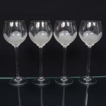 Belíssimo conjunto de taças de pé alto, para água, executado em fino cristal europeu, diáfano e incolor; bojo globular, fundo preenchido e talhado com flor acentinada, fuste tubular alongado sobre base circular. Composto de quatro(04) unidades. Medida: Alt.: 23,5 x Diam.: 8,5 cm.