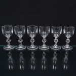 Elegante conjunto de taças de pé alto, para licor, em meio cristal, diáfano e incolor; bojo cilíndrico, liso, fuste oitavado, com anel intermediário multifacetado, e base circular. Composto de seis(06) unidades. Medidas: Alt.: 11 x Diam.: 5 cm.