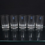 CRISTAL BLUMENAU. Conjunto de copos em cristal nacional, diáfano e incolor, formato cilíndrico de base espessa. Composto de cinco(05) unidades. Medidas: Alt.: 11 x Diam.: 7 cm.