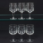 Conjunto de taças de pé alto, para vinho do Porto, em vidro, translúcido e incolor; bojo de formato cilíndrico, ricamente talhado com motivo de flores estilizadas, fuste tubular sobre base circular. Composto de seis(06) unidades. Medidas: Alt.: 12,5 x Diam.: 5,5 cm.