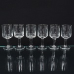 Conjunto de taças de pé alto, para licor, em vidro, translúcido e incolor; bojo de formato cilíndrico, ricamente talhado com motivo de flores estilizadas, fuste tubular sobre base circular. Composto de seis(06) unidades. Medidas: Alt.: 9,5 x Diam.: 4 cm.