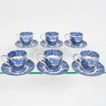 Belíssimo conjunto de xícaras para café em faiança, esmalatgem de tom marfim, decoração monocromática azul aplicada em estampagem sob o vidrado, padrão paisagístico com cenas campestres, árvores, arquitetura rural e elementos florais dispostos em friso contínuo; bojo obcônico, asa lateral aplicada de seção curva, padrão decorativo replicado no pires. Base com marca Drohaoser Com. Ind. S.A., produzido na Zona Franca de Manaus, Brasil. Composto de seis(06) unidades. Medidas: Alt.: x Comp.: x Larg.: ; Pires: Diam.: