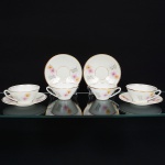 Porcelana Real, Mauá - SP(Fundada em 1943 por Fritz Erwin Schmidt). Quatro(04) xícaras para chá em porcelana nacional da década de 1960, estilo Art Déco; esmaltagem vítrea na cor branca, decoração aplicada por estampagem policromada, com motivos florais estilizados compostos por flores radiais em tons de rosa e amarelo, acompanhadas por folhas em grisaille, distribuídos no corpo, filetes dourados aplicados na borda superior do corpo e na base; bojo obcônico e alça lateral estilizada. Marca da manufatura no verso. Medidas: Xícara: Alt.: 5 x Comp.: 12 x Larg.: 10 mcm; Pires: Diam.: 14,5 cm.