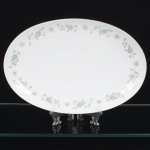 NORITAKE, Nagoya - Japão(Fundada em 1904 pelos irmãos Ichizaemon e Toyo Morimura). Elegante travessa oval em porcelana japonesa da década de 1960/70. Padrão 'WELLESLEY 6214', produzido entre os anos de 1961 a 1976. Esmaltagem vítrea na cor branca, decorada com delicado padrão floral com flores brancas, folhas em suave tons de verde e outros tons pastéis, borda contornada por friso em platina. Marca da manufatura no verso. Med.: Comp. 31,5 x Larg. 21 cm.