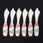 Conjunto de seis(06) espátulas em porcelana, cabo ornamentado com flores em estampagem policromada, delimitado por friso em douradura, lâmina curvada. Medida: Comp.: 12 cm.