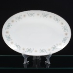 NORITAKE, Nagoya - Japão(Fundada em 1904 pelos irmãos Ichizaemon e Toyo Morimura). Grande travessa oval em porcelana japonesa da década de 1960/70. Padrão 'WELLESLEY 6214', produzido entre os anos de 1961 a 1976. Esmaltagem vítrea na cor branca, decorada com delicado padrão floral com flores brancas, folhas em suave tons de verde e outros tons pastéis, borda contornada por friso em platina. Marca da manufatura no verso. Med.: Comp. 36,5 x Larg. 24 cm.