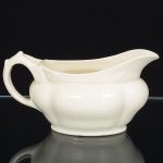 W.H. Grindley & Co., Stroke-on-Trent - Inglaterra(Fundada em 1880 por William Harry Grindley). Molheira navicular da década de 1930/40, esmaltagem de tonalidade creme, bojo moldado em gomos, borda ondulada com vertedouro frontal revirado, alça lateral curvada. Marca da manufatura ao fundo. Medidas: