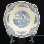 Indústrias Reunidas Fábricas Matarazzo (IRFM), São Caetano do Sul - SP(Fundada em 1926 / ativa até a década de 1950). Bowl em faiança nacional da década de 1940, esmaltagem de tom marfim, borda de contorno lobulado, aba decorada por cercadura contínua em azul aplicada por transferência, composta por reservas florais, cartelas ornamentais e motivos geométricos intercalados, centro com cena paisagem composta por torre, casas, vegetação e fundo com céu anuviado. Apresenta leves marcas do tempo. Marca da manufatura no verso. Medidas: Alt.: 6,5 x Diam>: 24,5 cm.