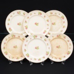 Johnson Brothers, Staffordshire - Inglaterra(Fundada em 1883). Belíssimo conjunto de pratos rasos ingleses, da década de 1930/40, executado em faiança; esmaltagem de tonalidade marfim, dotada de decoração com padrão de flores em estampagem policromada, predominando as tonalidades verde, rosa e castanho, distribuídas ao redor da orla e ao centro, borda modelada com movimento ondulatório, contornada por friso em douradura. Composto de seis(06) unidades. Medida: Diam.: 22,5 cm. Apresentam manchas do tempo, vide foto.