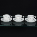 NORITAKE, Nagoya - Japão(Fundada em 1904 pelos irmãos Ichizaemon e Toyo Morimura). Três(03) xícaras para café em porcelana japonesa da década de 1960/70. Padrão 'WELLESLEY 6214', produzido entre os anos de 1961 a 1976. Esmaltagem vítrea na cor branca, decorada com delicado padrão floral com flores brancas, folhas em suave tons de verde e outros tons pastéis, bordas contornadas por friso em platina, bojo oval, alça lateral em voluta, padrão decorativo replicado no pires. Marca da manufatura no verso. Meds.: Xícara: Alt. 5 x Comp. 8,5 x Larg. 6,5 cm; Pires: Diam. 12 cm.