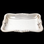 Elegante travessa para pão confeccionada em metal espessurado à prata, formato retangular de quinas arredondadas, centro rebaixado, borda ondulada e relevada com volutas estilizadas. Medidas: Alt.: 3 x Comp.: 27 x Larg.: 19 cm.